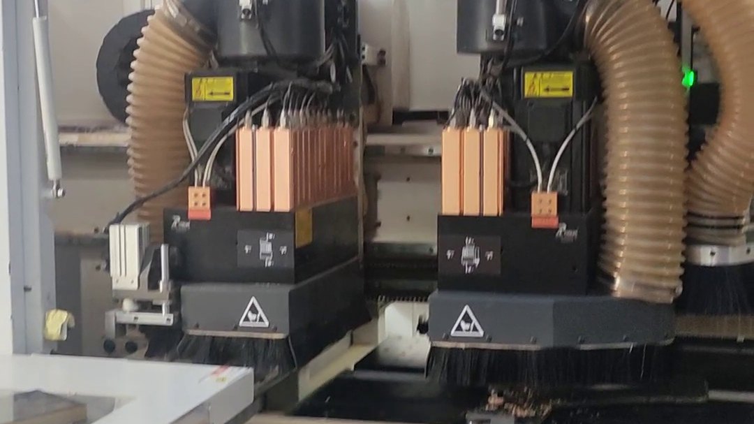 Beyond Emission Grades: Choosing Plywood That Survives Singapore's Humidity Multi-spindle drilling heads working over a board on a CNC machining centre, with wood chips on the table.