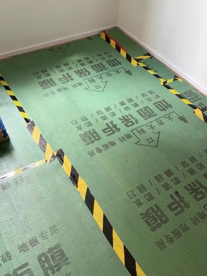 Dust, Noise and Smell Control for Works in a Live Building Floor protection sheeting taped and edged with hazard tape inside a works area